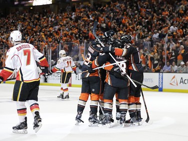 Anaheim Ducks players celebrate a goal by Jakob Silfverberg, of Sweden, as Calgary Flames' T.J. Brodie, left, and Mikael Backlund, of Sweden, skate away during the second period in Game 1 of a first-round NHL hockey Stanley Cup playoff series Thursday, April 13, 2017, in Anaheim, Calif. (AP Photo/Jae C. Hong) ORG XMIT: CAJH116