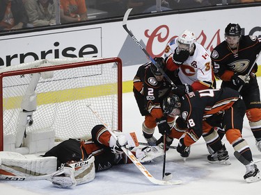 Calgary Flames' Troy Brouwer (36) is defended by Anaheim Ducks' Kevin Bieksa (2) and Logan Shaw (48) as Ducks goalie John Gibson falls to the ice trying to stop a shot during the third period in Game 1 of a first-round NHL hockey Stanley Cup playoff series Thursday, April 13, 2017, in Anaheim, Calif. The Ducks won 3-2. (AP Photo/Jae C. Hong) ORG XMIT: CAJH122