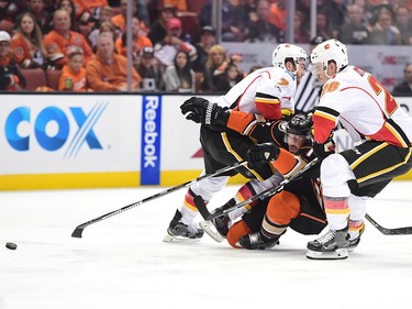 ANAHEIM, CA - APRIL 13:  Ryan Kesler #15 of the Anaheim Ducks is checked as he attempts to split the defense of  TJ Brodie #7 and Michael Stone #26 of the Calgary Flames during the first period in Game One of the Western Conference First Round during the 2017 NHL Stanley Cup Playoffs at Honda Center on April 13, 2017 in Anaheim, California.  (Photo by Harry How/Getty Images)