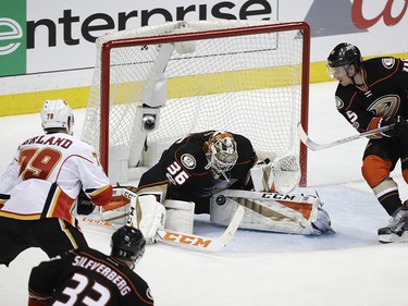Anaheim Ducks goalie John Gibson, center, stops a shot by Calgary Flames' Micheal Ferland, left, during the third period in Game 1 of a first-round NHL hockey Stanley Cup playoff series Thursday, April 13, 2017, in Anaheim, Calif. The Ducks won 3-2. (AP Photo/Jae C. Hong) ORG XMIT: CAJH124