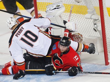 Anaheim Ducks Corey Perry collides with Matt Stajan of the Calgary Flames in front of Brian Elliott during 2017 Stanley Cup playoffs in Calgary, Alta., on Monday, April 17, 2017. AL CHAREST/POSTMEDIA