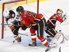 Anaheim Ducks Antoine Vermette, left and Calgary Flames Dougie Hamilton, middle, collide infant of Flames goalie Brian Elliott during NHL playoff action at the Scotiabank Saddledome in Calgary, Alta. on April 17, 2017.