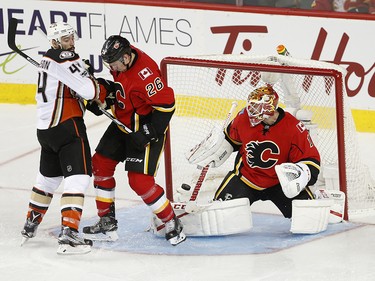 Anaheim Ducks Nate Thompson, left and Calgary Flames Michael Stone battle it out as the ducks score the overtime goal on Flames goalie Brian Elliott during NHL playoff action at the Scotiabank Saddledome in Calgary, Alta. on Monday April 17, 2017. Leah Hennel/Postmedia