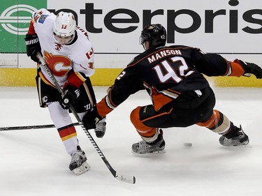 Calgary Flames left wing Johnny Gaudreau, left, works against Anaheim Ducks defenseman Josh Manson for the puck during the second period in Game 2 of a first-round NHL hockey Stanley Cup playoff series in Anaheim, Calif., Saturday, April 15, 2017. (AP Photo/Chris Carlson) ORG XMIT: ANA115