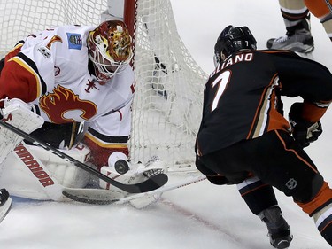 Calgary Flames goalie Brian Elliott, left, blocks a shot by Anaheim Ducks center Andrew Cogliano during the third period in Game 2 of a first-round NHL hockey Stanley Cup playoff series in Anaheim, Calif., Saturday, April 15, 2017. (AP Photo/Chris Carlson) ORG XMIT: ANA116