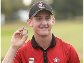 Jared du Toit holds up the Gary Cowan Award for being the low amateur at the Canadian Open at Glen Abbey in Oakville, Ont., on Sunday, July 24, 2016. (The Canadian Press)
