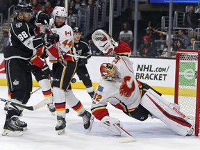 Calgary Flames goalie Jon Gillies (32) stretches to protect the goal, with defenseman Matt Bartkowski (44) and Los Angeles Kings right winger Jarome Iginia (88) in the mix during the second period of an NHL hockey game in Los Angeles on Thursday, April 6, 2017.