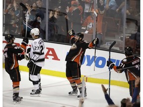 Anaheim Ducks' Nate Thompson, center, Brandon Montour, right, and Chris Wagner, left, celebrate a goal by Thompson as Los Angeles Kings' Alec Martinez skates away on Sunday, April 9, 2017, in Anaheim, Calif. The Ducks won 4-3 in overtime. (AP Photo)