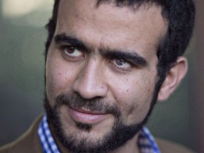 Omar Khadr watches as his lawyer Dennis Edney speaks to media after his bail conditions hearing in Edmonton on Friday, September 11, 2015. Khadr's official criminal record in Canada contains oddities and errors that are at odds with how the federal government viewed him on his return from the notorious prison on the U.S. naval base at Guantanamo Bay, Cuba.