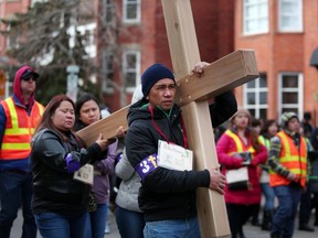 Participants carry the cross during the Way of the Cross on Good Friday in Calgary, Alta., on Friday April 14, 2017.
