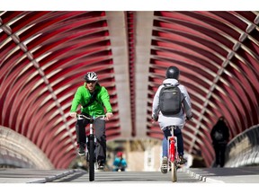 People cycle across the Peace Bridge in downtown Calgary.