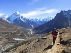 A trekker hiking through the everest mountain range towards the Cho-La pass.