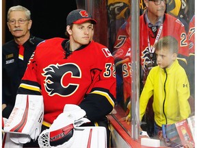 Calgary Flames goalie Jon Gillies is seen next to a young fan during a break in play against the Boston Bruins in Calgary on March, 15, 2017. (Al Charest)