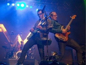 Rivers Cuomo of Weezer, left, joins bassist Scott Shriner, right, at the front of the stage as they rock the crowd at Rock The Park in Harris Park in London on Thursday July 24, 2014. CRAIG GLOVER The London Free Press / QMI AGENCY ORG XMIT: POS1610161544499591