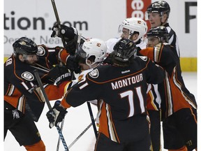 Anaheim Ducks center Ryan Kesler, left, fights Calgary Flames center Sean Monahan, second from left, as defenseman Brandon Montour (71) and left wing Andrew Cogliano, right, pull on defenseman TJ Brodie, third from right, during the third period of an NHL hockey game in Anaheim, Calif., Tuesday, April 4, 2017. The Ducks won 3-1.