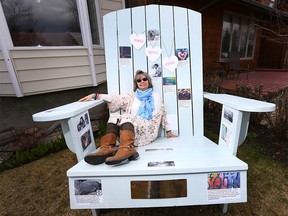 Dina Salivan poses on a giant Adirondack chair in front of her house in southwest Calgary on Friday April 28, 2017. Her supporters built a giant 'Pay it Forward' chair with inspirational quotes. Jim Wells//Postmedia