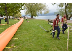 KELOWNA, B.C. MAY 16, 2017  Employees with the BC Wildfire Service help set up aqua dams at Pritchard Park in West Kelowna on Tuesday. Work crews continue to install flood protection for rising lake levels at various locations around the Central Okanagan area, the work includes aqua dams , gabion barriers and sandbags along the lakefront. Survey stakes have also been placed along waterfront properties to show where the lake level could reach when it hits the 3.43.6-metre level. [PNG Merlin Archive]