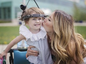 Ruby de Boer, 3, and her mother Stacey are pictured behind the Alberta Children's Hospital on Friday, May 12, 2017. Ruby, born with a rare condition, has spent the past two months confined to a halo traction device designed to gently pull her head upwards and gradually straighten her spine, so the girl and her family will spend Mother's Day in hospital. KERIANNE SPROULE/POSTMEDIA