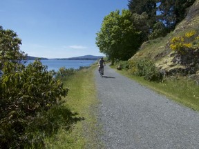 A cyclist rides past Sooke Basin toward Victoria on the 55-km Galloping Goose Trail. An old railway bed, the gentle grade makes for easy pedalling. Credit, Alex and Valerie Berenyi