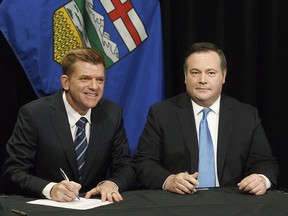 Alberta Wildrose leader Brian Jean and Alberta PC leader Jason Kenney sign a unity deal between the two in Edmonton on Thursday, May 18, 2017.