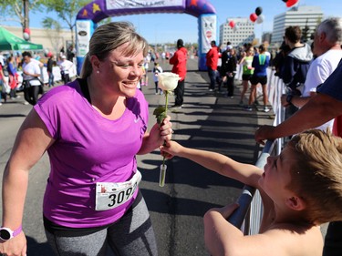 George Matheos, 6, hands a rose to his mom after she finished the Sport Chek Mother's Day Run and Walk at Chinook Centre on Sunday May 14, 2017. The event supports neonatal units in Calgary as well as Jumpstart for Kids.