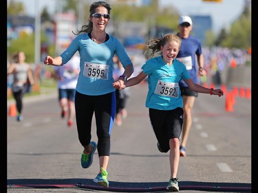 Ava Shaw, 12, holds hands with her mom Stephanie at the finish line of the Sport Chek Mother's Day Run and Walk at Chinook Centre on Sunday May 14, 2017. The event supports neonatal units in Calgary as well as Jumpstart for Kids.