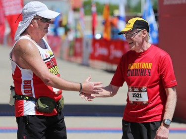Richard Stewart, left and Roger MacMillan shake hands  after finishing the Scotiabank Calgary Marathon on Sunday May 28, 2017.