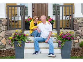 Valerie Bertoncini and George Carnegie sit on the front step of their new home by Hopewell Residential in Mahogany.