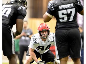 Connor McGough from the University of Calgary, centre, sizes up opposing players Asare Kwabena, left, and Qadr Spooner during drills at the 2017 CFL Combine at the Co-operators Centre in Regina on March 25, 2017. (The Canadian Press)