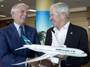 WestJet president and CEO Gregg Saretsky, left, and board chairman Clive Beddoe hold a model of a Boeing 787 Dreamliner. The company is buying the jets to serve far-off destinations.