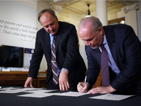 B.C. NDP Leader John Horgan and Green Party Leader Andrew Weaver sign an agreement they hope will allow them to form government in British Columbia.