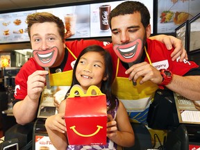 Calgary Stampeders  Quinn Smith and Rene Paredes serve Naomi Gagner, 8, in support of McHappy Day at Stadium McDonald's Wednesday.