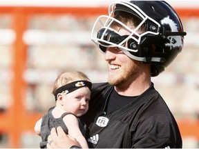 Calgary Stampeders QB Bo Levi Mitchell with his new daughter Ele after CFL training camp at McMahon stadium in Calgary, Alta., on Sunday, May 28, 2017. DARREN MAKOWICHUK/POSTMEDIA