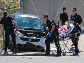 Police and EMS help a woman injured in a hit and run collision at 9th avenue and 4th Street S.E. on Monday May 8, 2017. Three cars were damaged and the occupants of the suspect vehicle fled on foot.
