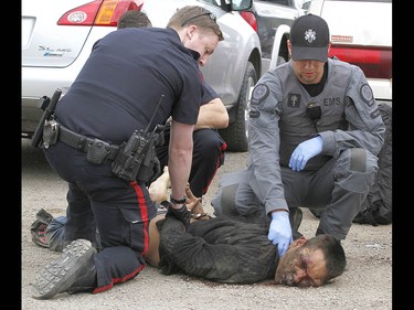 Calgary Police take into custody two men after a collision on Parkdale Blvd and Shaganappi Tr NW about 1 pm in Calgary on Tuesday May 9, 2017. The alleged stolen vehicle crashed into at least two other vehicles. The men were taken into custody in a parking lot near Edworthy Park. The were treated at scene by EMS for a variety of injuries. Jim Wells//Postmedia