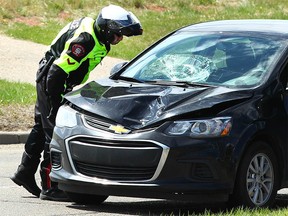 Calgary Police investigate at the scene of a serious car/pedestrian collision at Canyon Meadows Dr and 6 St SW in Calgary on Saturday May 6, 2017. Police say a woman was struck by a car around noon and taken to hospital with life threatening injuries. Jim Wells//Postmedia