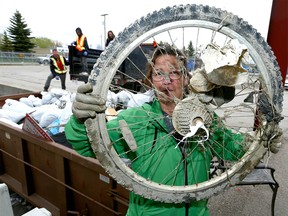 Judy Johns, who works in the Urban Forestry Planting department shows a bike wheel unearthed during the 50th annual Pathway and River clean up in Calgary on Sunday May 7, 2017. Its the 11th year she has participated in the clean up and loves to help keep her city clean. Over 2900 registered volunteers collected and bagged garbage and trash along the nearly 200 km of pathways and river banks. Jim Wells//Postmedia