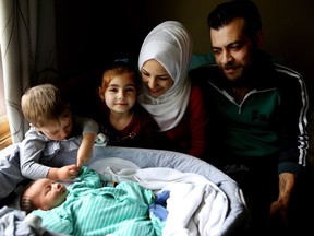 Afraa Bilan, 22, and her husband Muhammad, 29, with their children, Nael, 3, Naya, 5, and baby Justin Trudeau Adam, at their home in Calgary. The Syrian family came to Canada in February 2016.