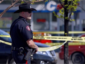 Investigators at the scene of a May 21 double slaying in the parking lot of a grocery store  in Mckenzie Towne.