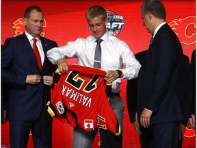 Juuso Valimaki puts on the Calgary Flames jersey after being selected 16th overall during the 2017 NHL Draft at the United Center on June 23, 2017 in Chicago, Illinois.