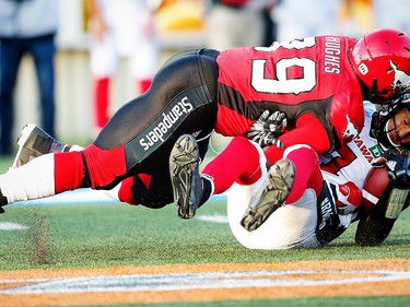 Ottawa Redblacks Trevor Harris is sacked by Charleston Hughes of the Calgary Stampeders during CFL football in Calgary. AL CHAREST/POSTMEDIA