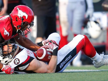 Calgary Stampeders Tommie Campbell brings down Greg Ellingson the Ottawa Redblacks during CFL football in Calgary. AL CHAREST/POSTMEDIA