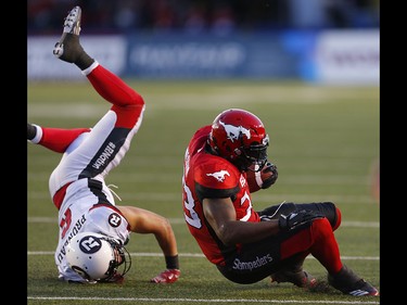 Calgary Stampeders Jerome Messam is knocked to the turf by Antoine Pruneau the Ottawa Redblacks during CFL football in Calgary. AL CHAREST/POSTMEDIA