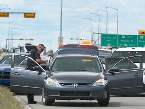Police take custody of a car following a traffic stop on eastbound 17 Ave S.E. near 84 St S.E. in Calgary on Saturday, June 17, 2017.
