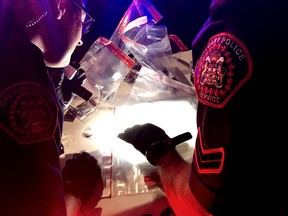 Members of the Calgary police beat unit bag evidence after arresting a break and enter suspect in Tuesday, June 27 2017. Bryan Passifiume/Postmedia Network