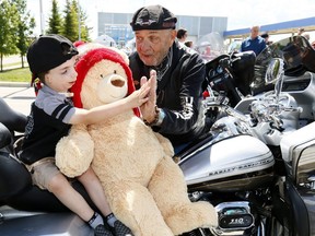 Patient, Lincoln Nitschke, 4, greets Tom Fredericks, ECL Choppers for Charity event founder and organizer as the Rotary Flames House in Calgary received a generous boost to their Respite Care service at Rotary Flames House as 50 bikers and passengers who make up the ECL Choppers for Charity handed over a $155,000 cheque to help children requiring complex care and their families. Since they began their support 15 years ago, Choppers for Charity has raised more than $2.5 million for the Alberta Childrens Hospital Foundation. on Saturday June 24, 2017. DARREN MAKOWICHUK/Postmedia Network