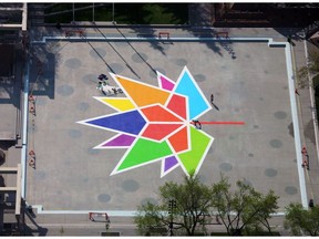 Painters put the finishing touches on the Canada 150 logo on Olympic Plaza in Calgary.