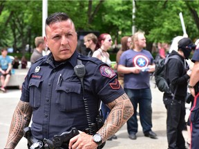 Calgary police Const. Kevin Starblanket keeps the peace during an anti-Islam rally at Calgary city hall in Calgary, Alta. on Saturday, June 3 2017. Bryan Passifiume/Postmedia Network