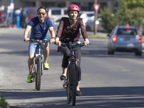 Postmedia reporter Annalise Klingbeil rides with Calgary city councillor Sean Chu along Northmount Drive, where a bike lane is proposed.