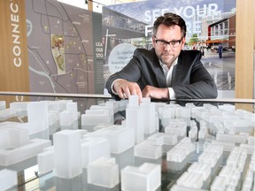 James Robertson President and CEO of West Campus Development Trust looks over a 3D model of the University District development in the Discovery Centre.